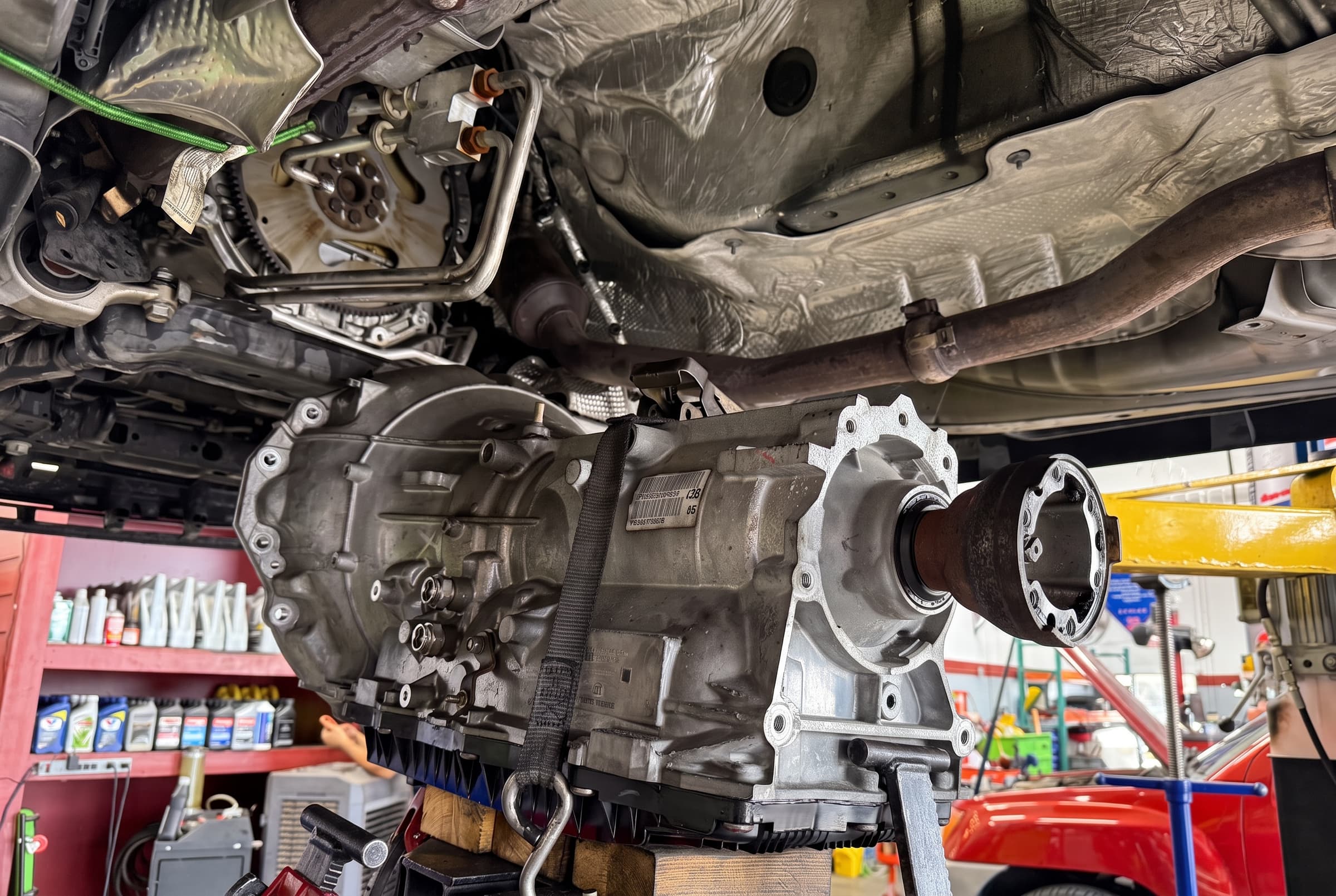 Transmission on a transmission jack under a vehicle at Johnny's Automotive