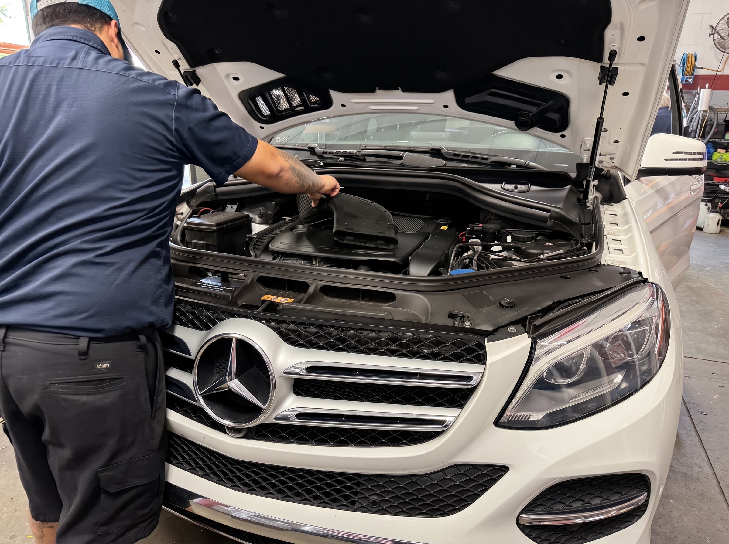 Johnny's Automotive technician working under the hood of an SUV