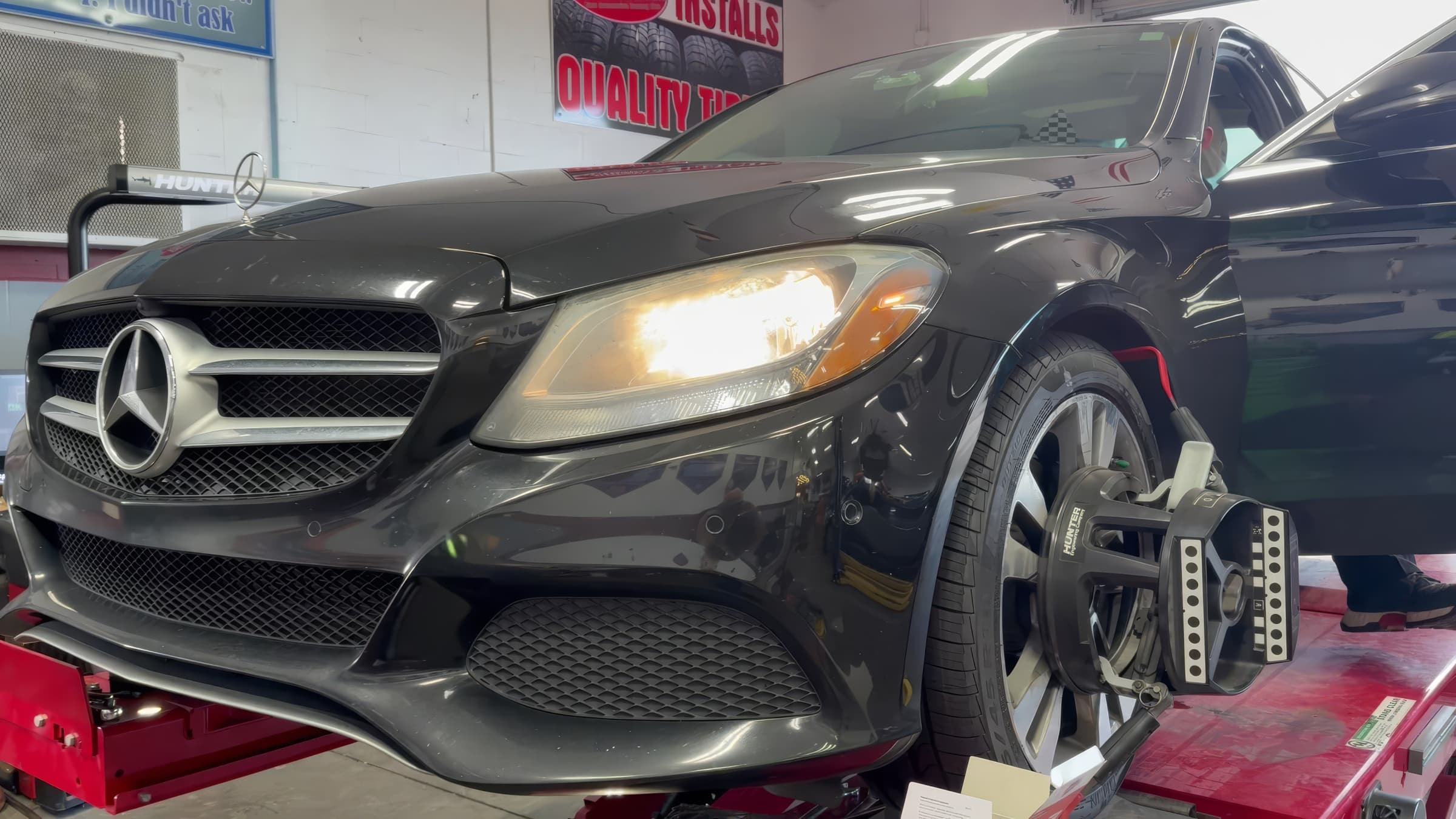 Sedan on the alignment rack with Hunter alignment targets on the wheels at Johnny's Automotive